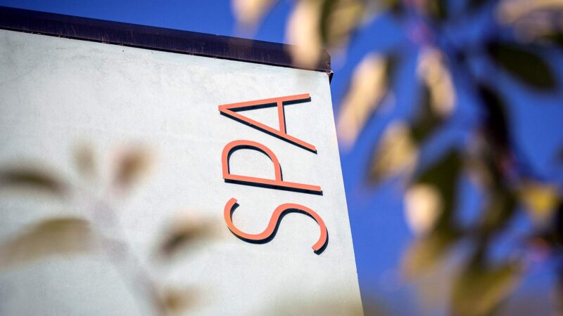Luxurious hotel spa sign against clear blue sky, promising relaxation and rejuvenation in a serene setting.