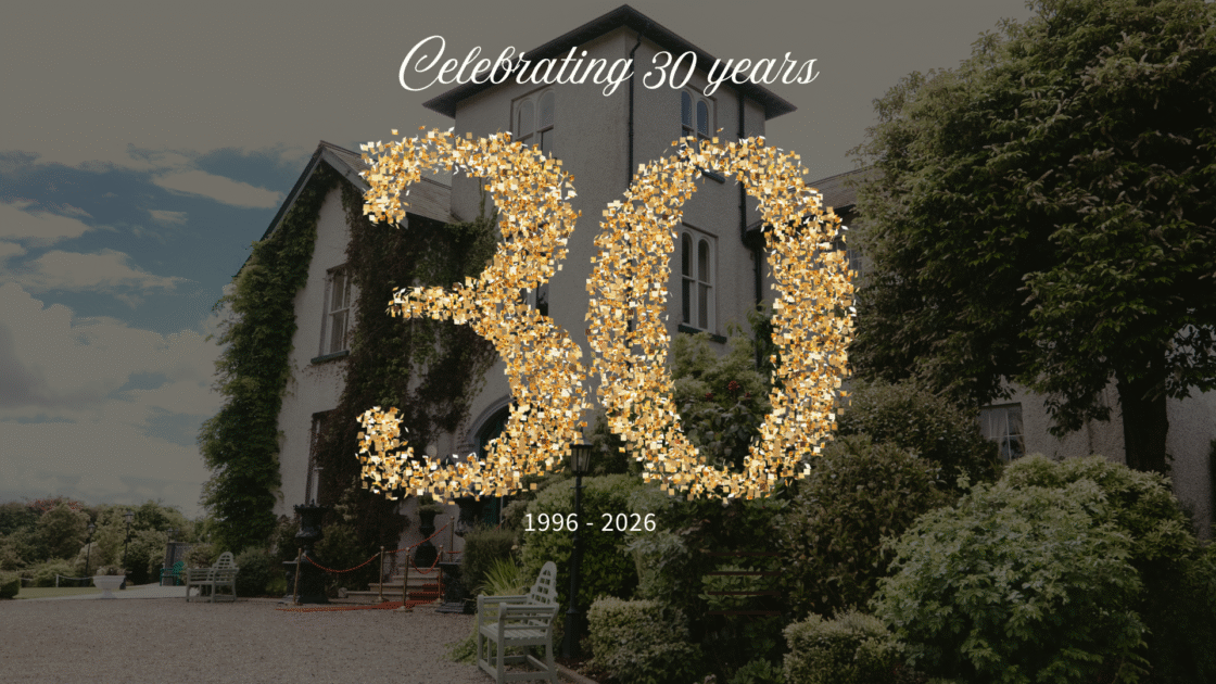 Celebrate at scenic hotel entry with lush gardens, enchanting atmosphere, and 30 years of welcoming hospitality.