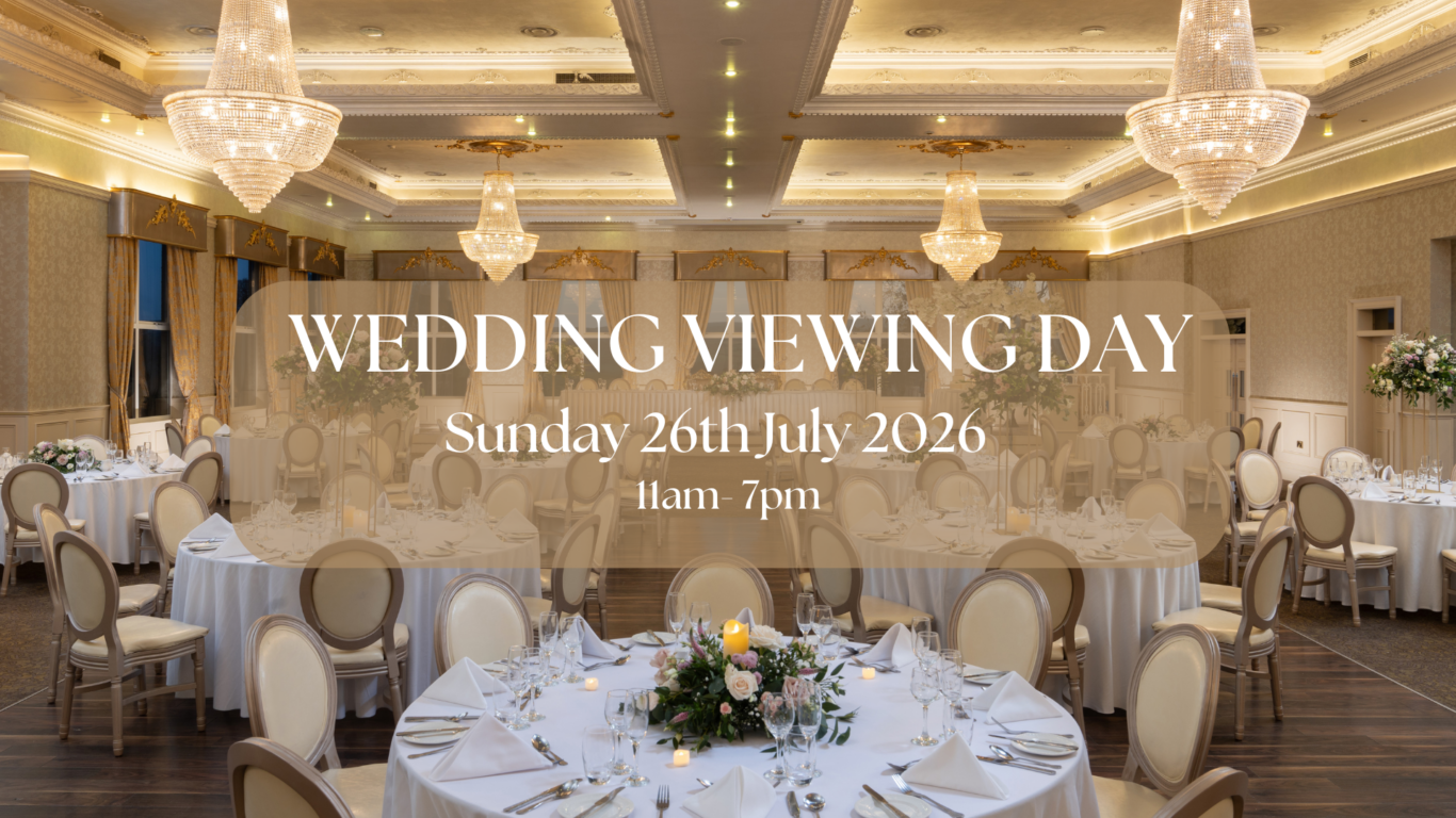 Elegant ballroom setup with chandeliers, round tables with white linens, perfect for weddings or events at our luxury hotel.