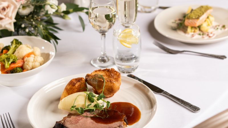 Elegant dining with roast beef, vegetables, and salmon at a hotel restaurant. Enjoy fine dining and luxury service.