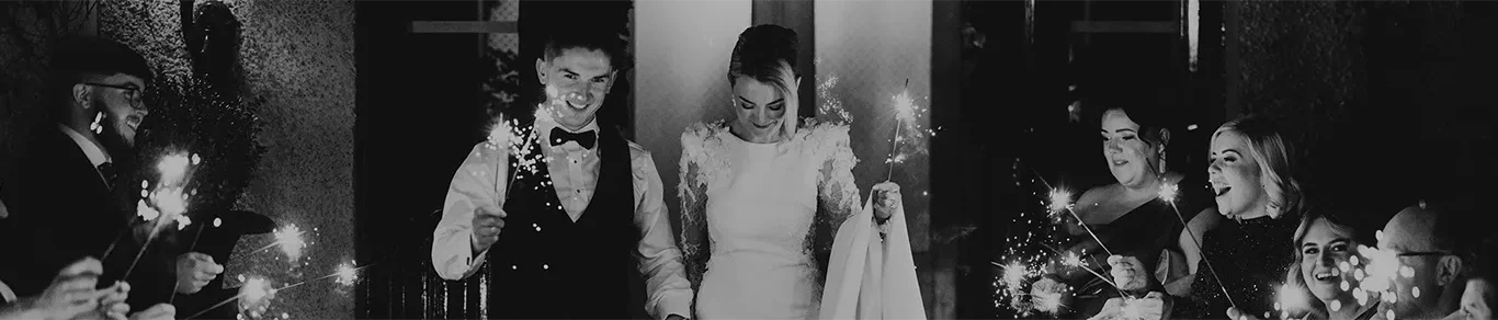 Wedding couple exits with sparklers, surrounded by joyful guests. Experience elegant celebrations at our luxury hotel venue.