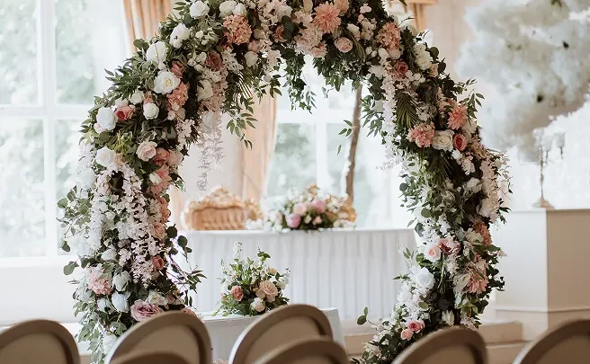 Elegant wedding venue with floral arch, elegant chairs and natural light, perfect for a romantic ceremony.